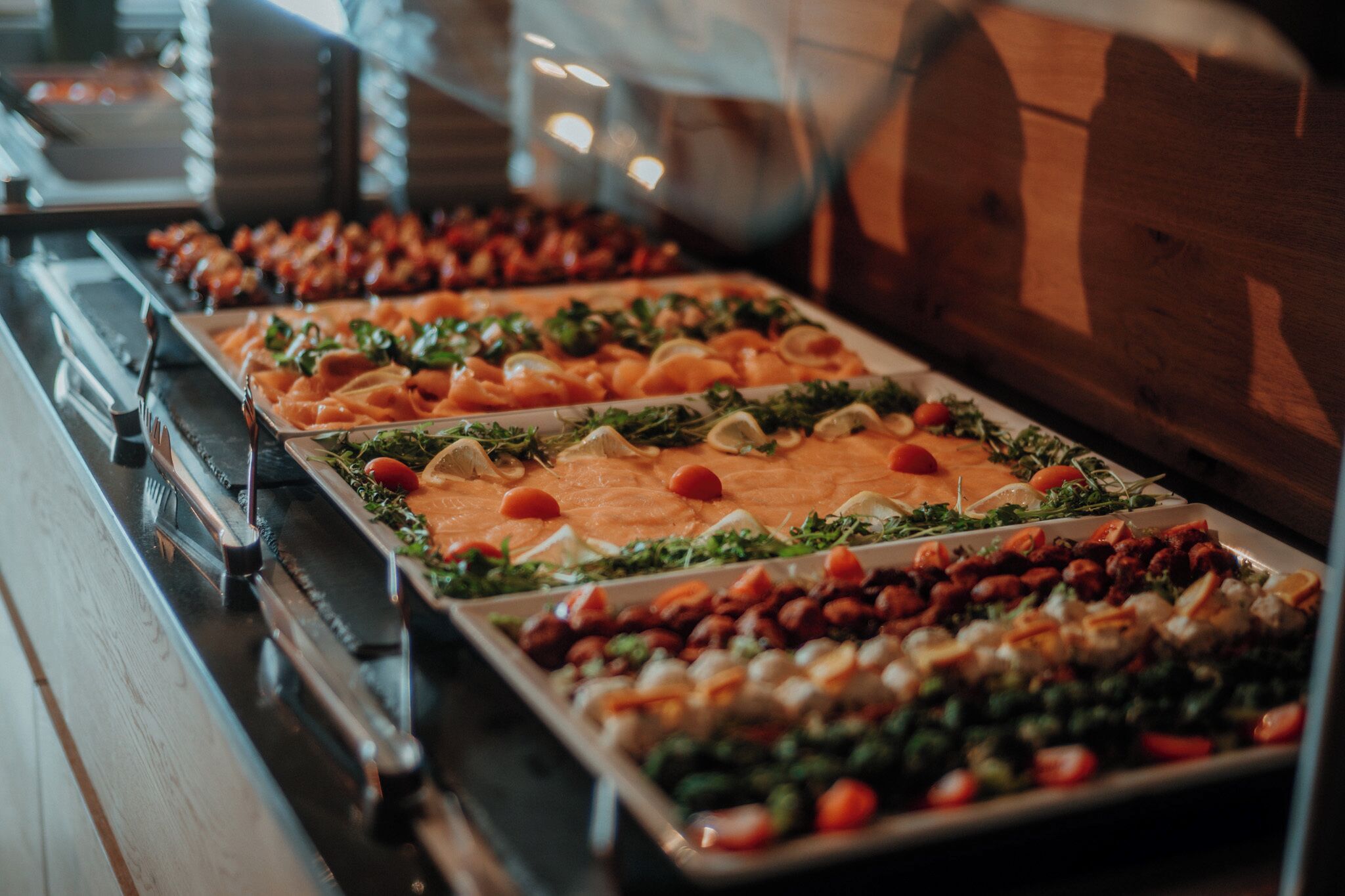 A buffet with various food items including salads, meats, and vegetables.