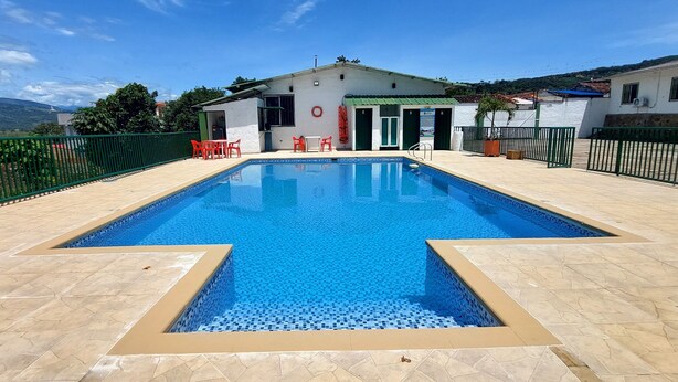 A rectangular swimming pool with a tiled edge, surrounded by a tiled deck. - HOTEL LIDERATO (Paramo)