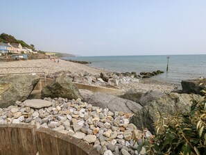 A rocky beach with a wooden walkway and a view of the sea. - The Dingle (Narberth)