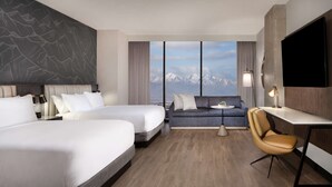 Habitación de hotel con dos camas, un sofá, un escritorio y una silla.