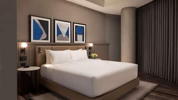 A modern hotel room with a large bed, a round bedside table, and a wall-mounted lamp.