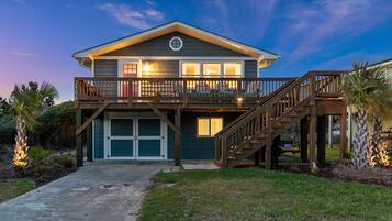 A two-story house with a balcony, a staircase, and a garage.