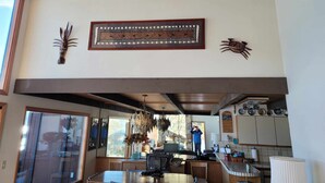 A modern kitchen with a stone backsplash, wooden ceiling beams, and a large window. - Gorgeous, sweeping views of Lake Tahoe from 3 story lake front condo! (Tahoe City)