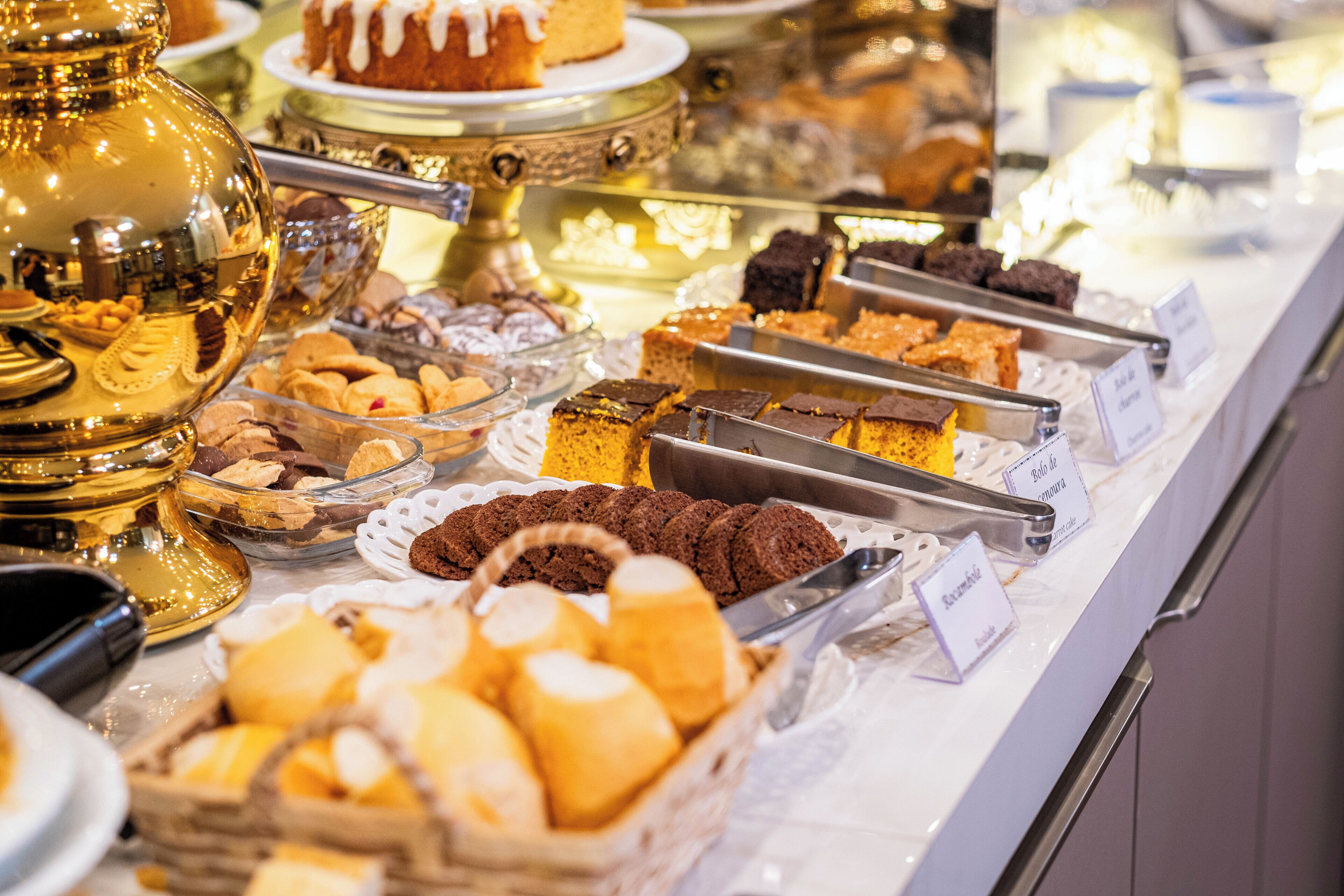 A buffet with various baked goods including cookies, cakes, and pastries.