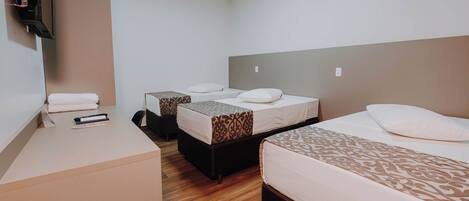 Une chambre d’hôtel avec deux lits, un bureau et un téléviseur à écran plat.