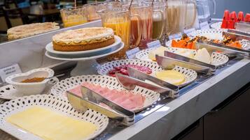 A buffet with various food items and beverages.
