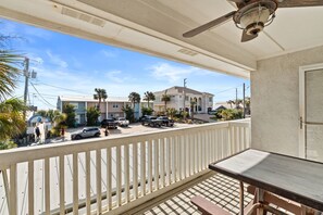 The balcony offers a relaxing setup with comfortable chairs, a cooling ceiling fan, and a charming café table perfect for morning coffee or evening unwinding. - Dog-Friendly, Steps to Beach & Gulf Sunsets | Beach Bungalow (Panama City Beach)