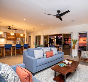 A modern living room with a sofa, coffee table, and dining area.