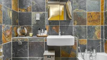 Bathtub, hair dryer, towels, toilet paper