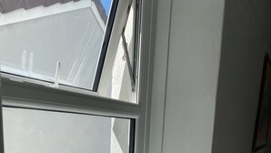 A window with a metal object on the sill. - Stunning 2-bed Apartment Above Schooners Bar (Neath)
