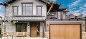 A luxury home with a two-story design, a large garage, and a front porch. It advertises 10 sleeping accommodations, a spa, and is pet-friendly.