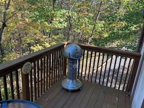 Une terrasse avec un barbecue et une horloge.