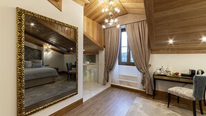 Een slaapkamer met een grote spiegel, een bed, een bureau en een stoel.