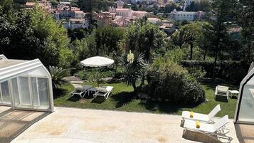 Una piscina con vistas a un pueblo y colinas al fondo.