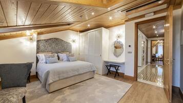 A bedroom with a bed, a chair, a desk, and a mirror.