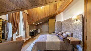 Quarto com cama, mesa de cabeceira, luminária na parede e teto de madeira.