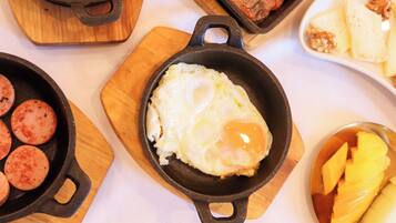 A breakfast spread with various dishes including eggs, sausages, and fruit.