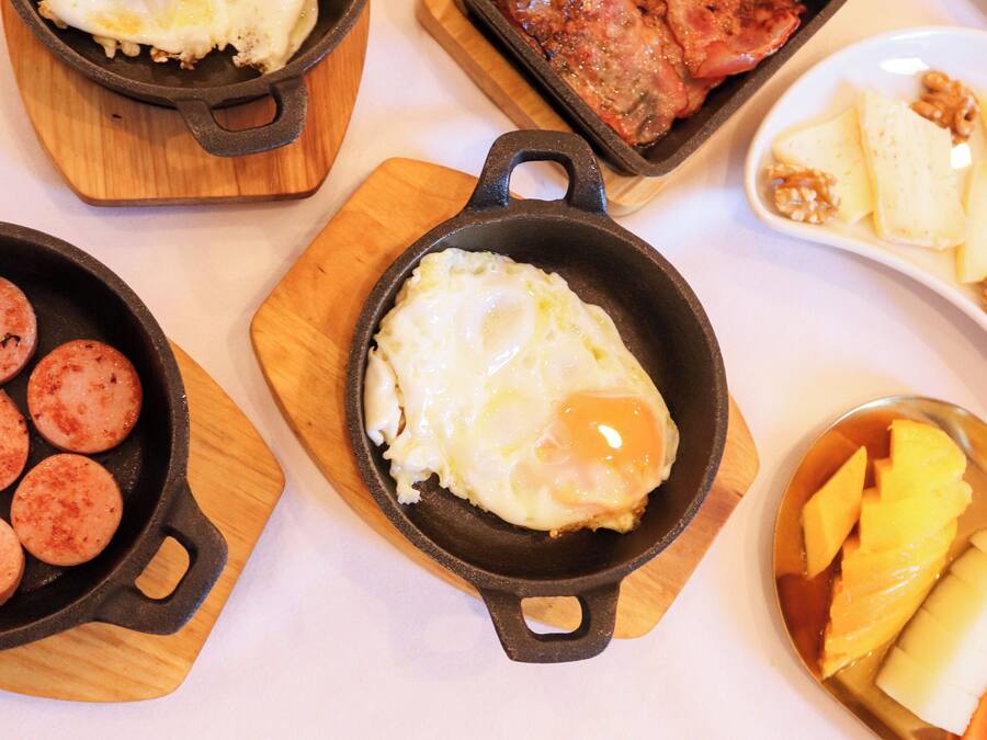 A breakfast spread with various dishes including eggs, sausages, and fruit.