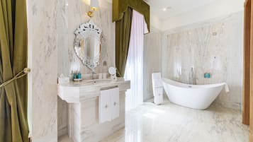 A modern bathroom with a freestanding bathtub, a large mirror, and a marble vanity.