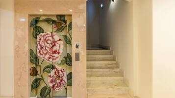 Una escalera de mármol con un mural floral en la pared.