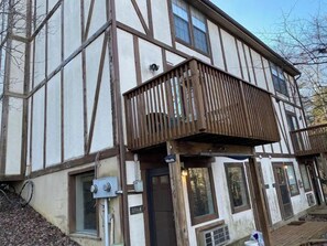 A half-timbered building with a balcony, a door, and a window. - Cozy Mountain Den (Basye)