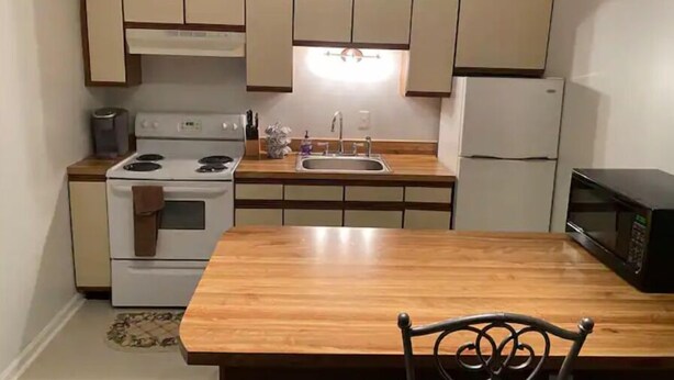 A compact kitchen with a stove, sink, and microwave. - Sunny Spitz Den (Basye)