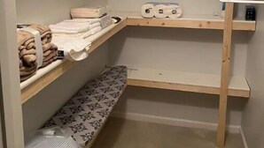 A corner storage unit with shelves, a bench, and a hanging rack. - Sunny Spitz Den (Basye)