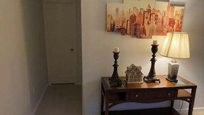 A hallway with a wooden table displaying a house model, candles, and a lamp. - Sunny Spitz Den (Basye)