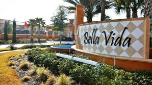 A sign with "Bella Vida" written on it, surrounded by landscaped greenery and palm trees. - Cozy 3 bedroom home with Private Pool 4564 (Kissimmee)