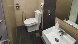 Un baño pequeño con inodoro, lavamanos y espejo.