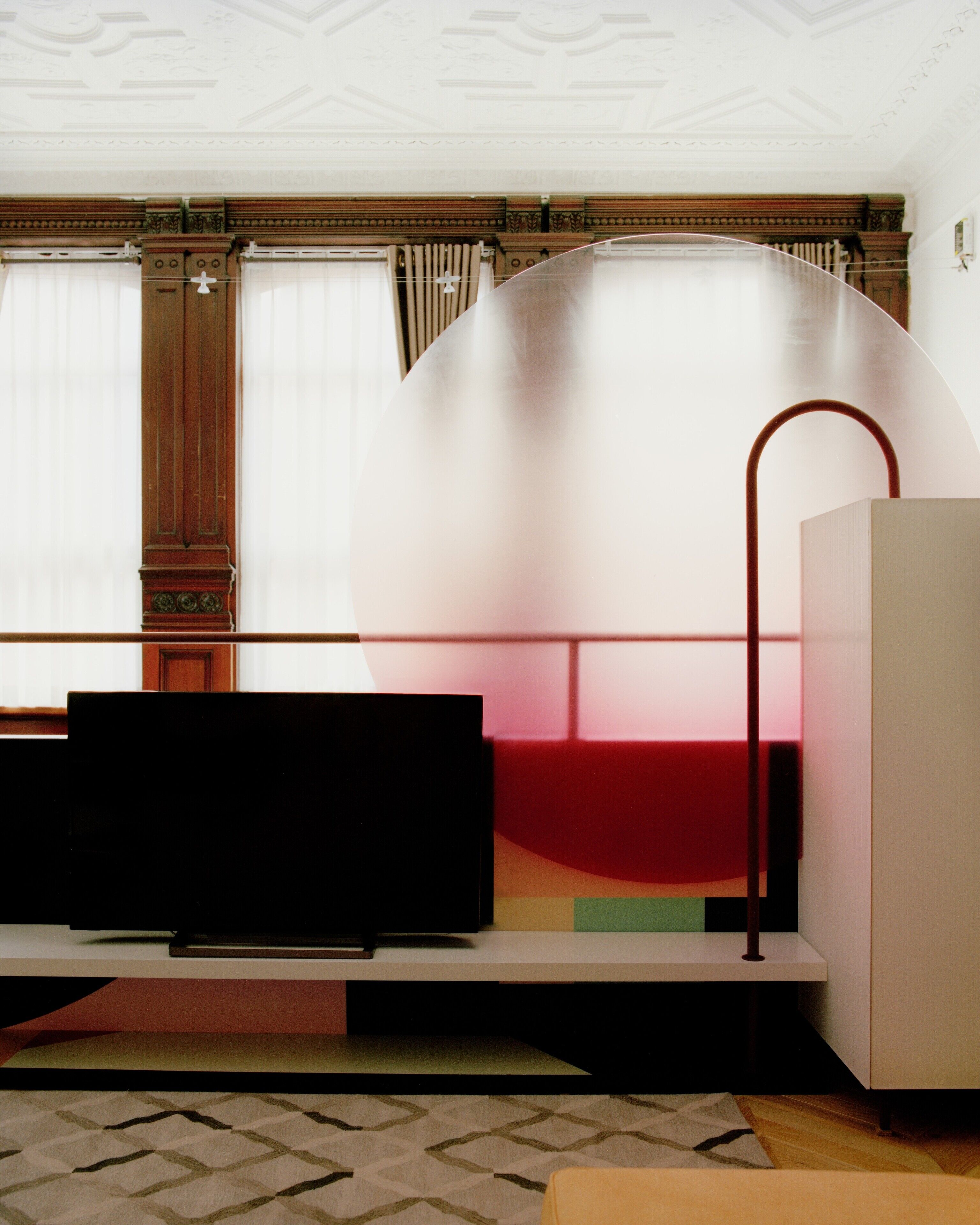 Ein modernes Zimmer mit einem großen Bett, einem Flachbildfernseher und einem weißen Schrank.