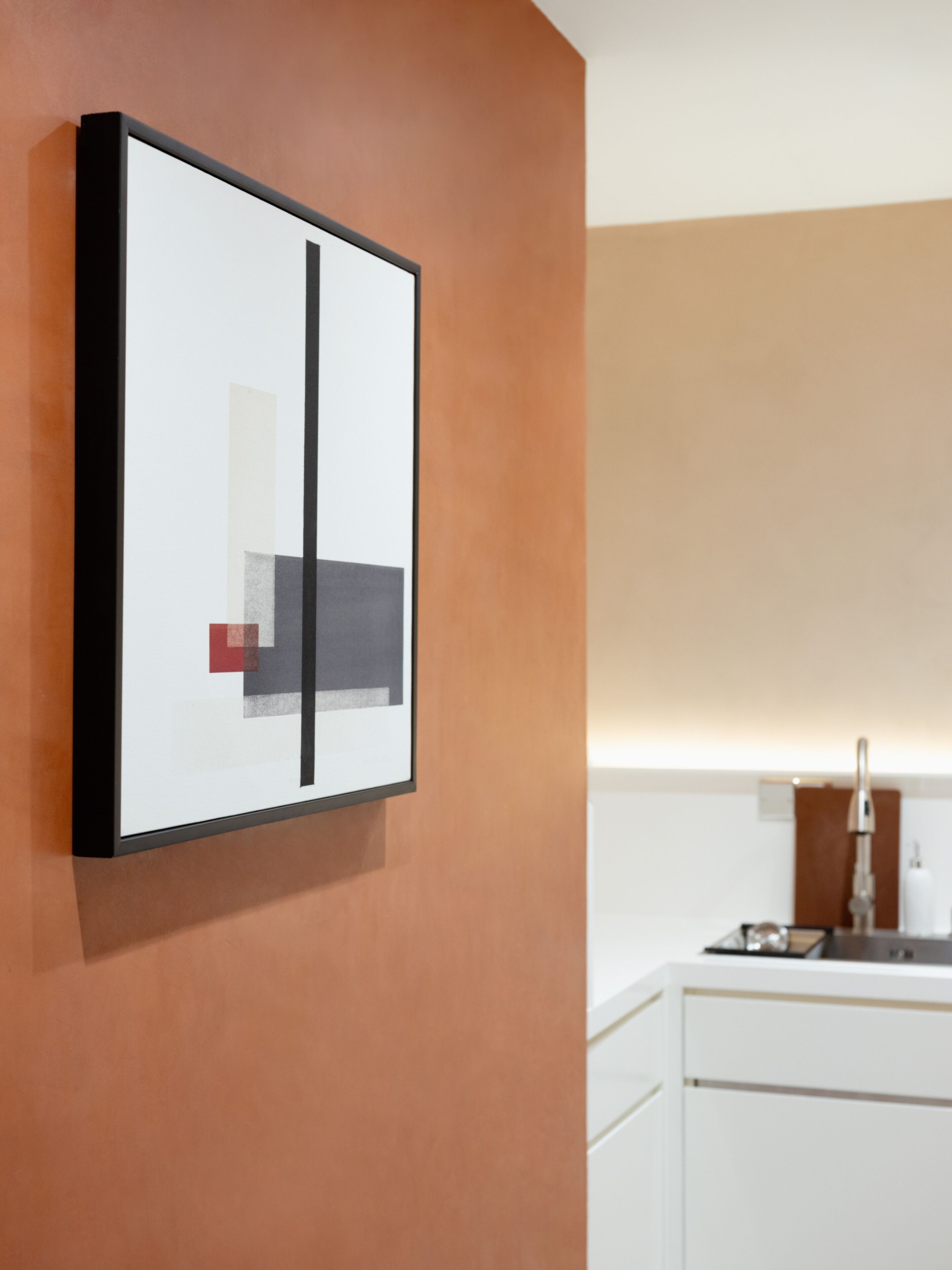 A framed abstract artwork on a wall.