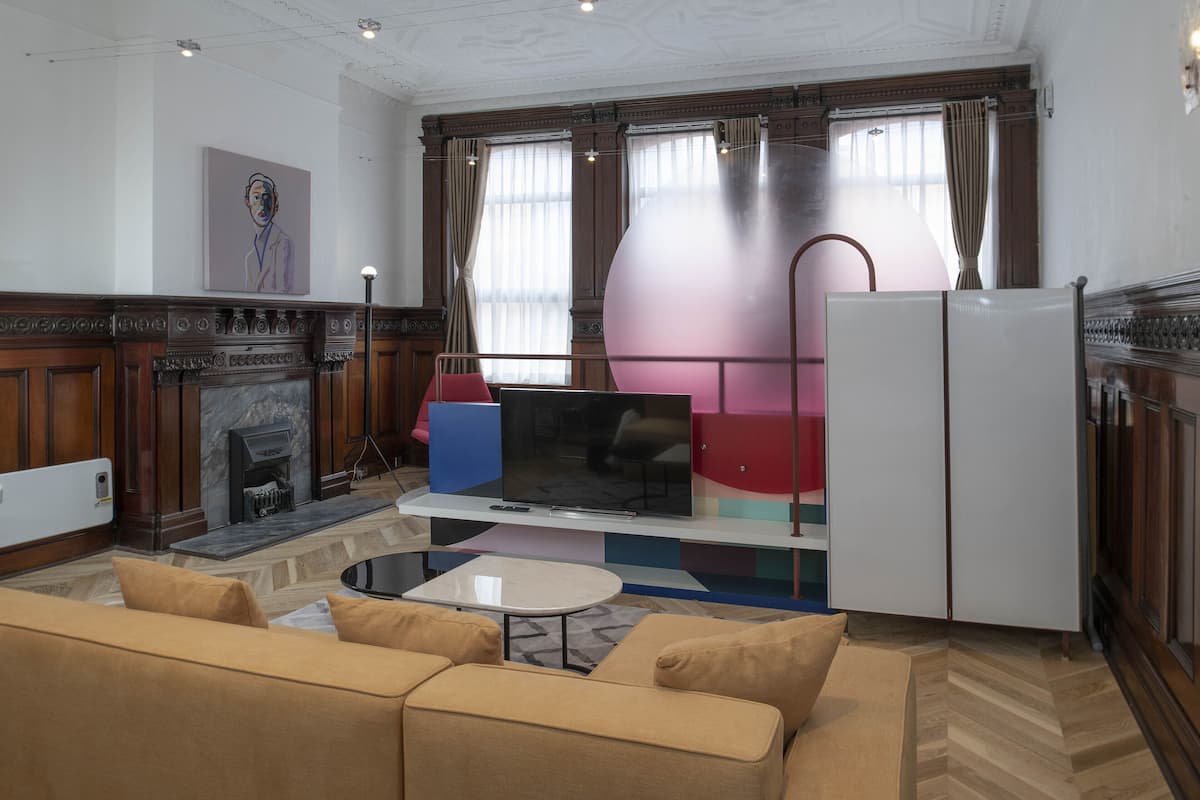 A modern living room with a fireplace, a television, a sofa, and a dining area.