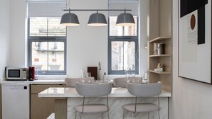 A modern kitchen with two bar stools, a microwave, and a dishwasher. - Trueman Court Luxury Serviced Apartments (Liverpool)