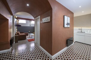 Un interno moderno con pavimento decorato, un divano, un tavolo da pranzo e un angolo cottura.