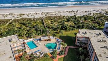 Un resort con zona de piscina, acceso a la playa y vistas al océano.
