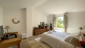 A bedroom with a bed, bedside table, desk, and dresser. There is a window with curtains, a small rug, and a wall-mounted decoration. - Charming Mas in the countryside, near the village of Lambesc, large garden, (Lambesc)
