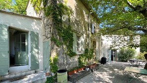A rustic courtyard with a gravel path, a wooden bench, and a table. - Charming Mas in the countryside, near the village of Lambesc, large garden, (Lambesc)