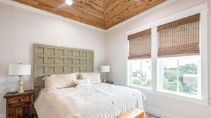 A bedroom with a wooden ceiling, a bed with white linens, two bedside lamps, a wooden bench, and a window with blinds. - Summer Kickoff Special! Beach House on 30A, Steps from the Beach! (Santa Rosa Beach)