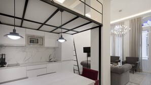 A modern kitchen with a marble countertop, a built-in microwave, and pendant lighting. - Fresh Velazquez Apartment C (Málaga)