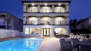 Un edifici de diverses plantes amb piscina, mobiliari d'exterior i balcons.