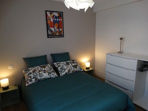 A bedroom with a bed, two nightstands with lamps, a dresser, and a framed picture on the wall. - Duplex Le Rheun, luxury apartment 800 m from the beach (Douarnenez)
