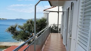 Ein Balkon mit Fliesenboden, Metallgeländer und Meerblick.