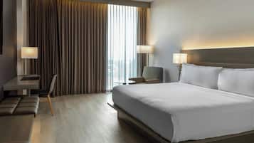 Une chambre d’hôtel moderne avec un grand lit, un bureau et une chaise.