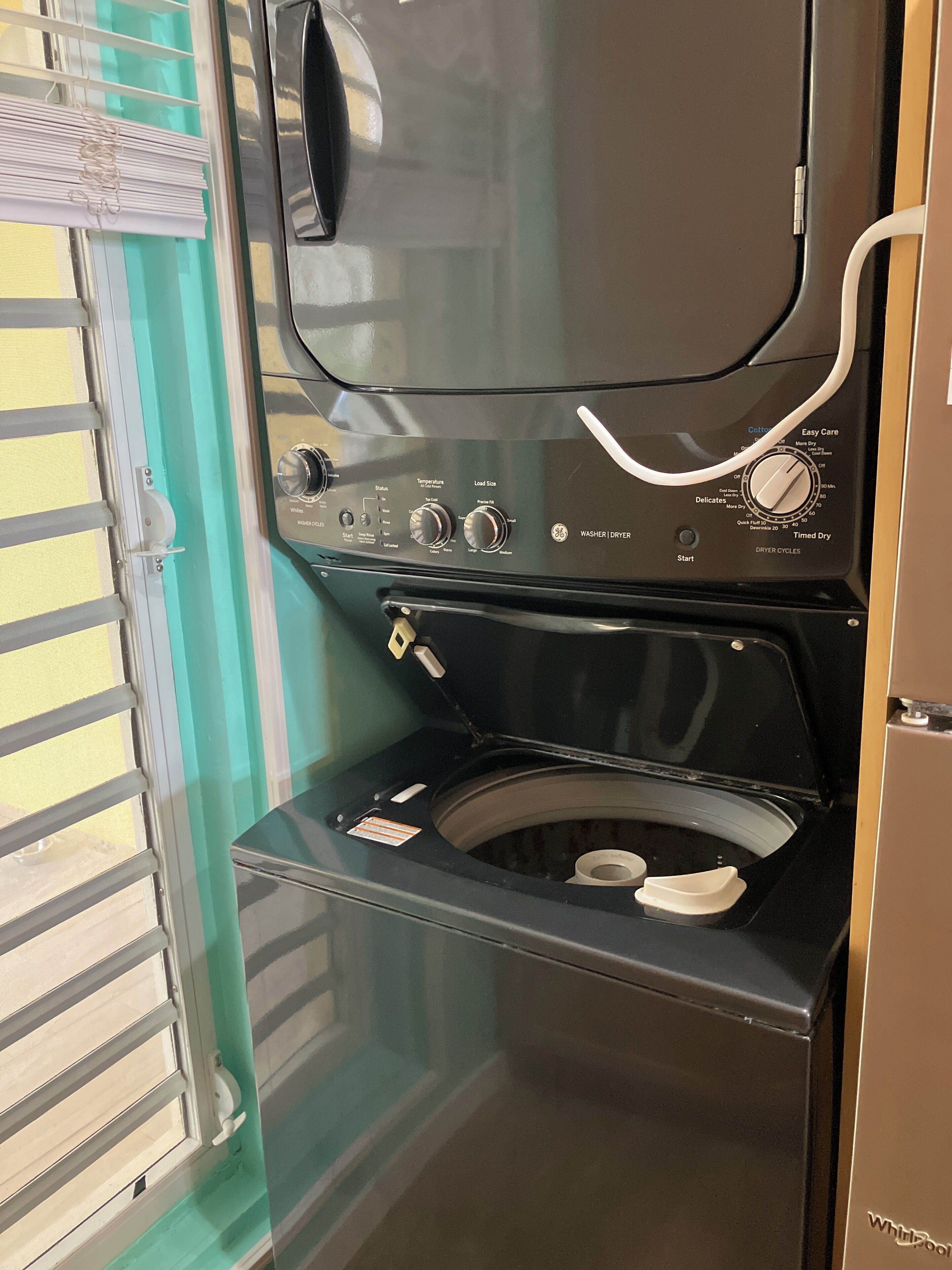 A compact, modern washer and dryer unit with a front-loading design, control panel with multiple settings, and a transparent door for easy viewing.