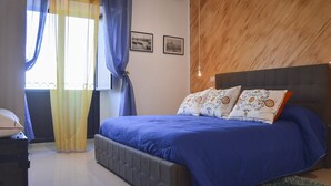 Une chambre à coucher avec un grand lit, une tête de lit en bois et deux tableaux encadrés accrochés au mur.