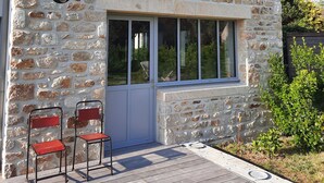 A stone building with a triangular roof, a circular window, and a door with a window. There are two red chairs outside. - beautiful new house near the sea, 3mn walking to the beach, very quiet (Combrit)