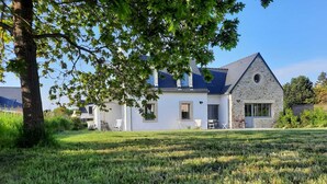 A two-story house with a stone exterior and a sloped roof. - beautiful new house near the sea, 3mn walking to the beach, very quiet (Combrit)