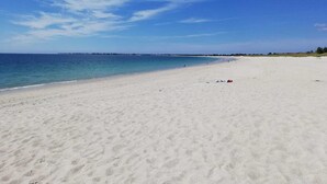 A wide sandy beach with a clear blue sky and calm sea. - beautiful new house near the sea, 3mn walking to the beach, very quiet (Combrit)