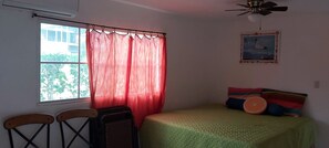A bedroom with a bed, a window with curtains, a ceiling fan, and a framed picture on the wall. - Traditional Colonial House, in private community 5 minutes from the Beachminutes (Canton San Blas)
